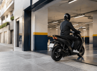 Motorista entrando en un parking urbano cubierto para aparcar la moto