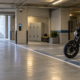 Moto sin marcas aparcada en una plaza amplia de un parking cubierto, con acceso, taquillas e iluminación visibles