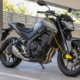 Motocicleta con cadena anclada y candado de disco con cable recordatorio en un aparcamiento cubierto genérico