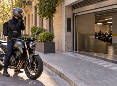 Motorista junto a la entrada de un aparcamiento cubierto en una calle urbana de Barcelona