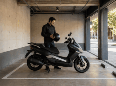 Motorista recoge su casco junto a una moto aparcada bajo techo para una estancia por horas
